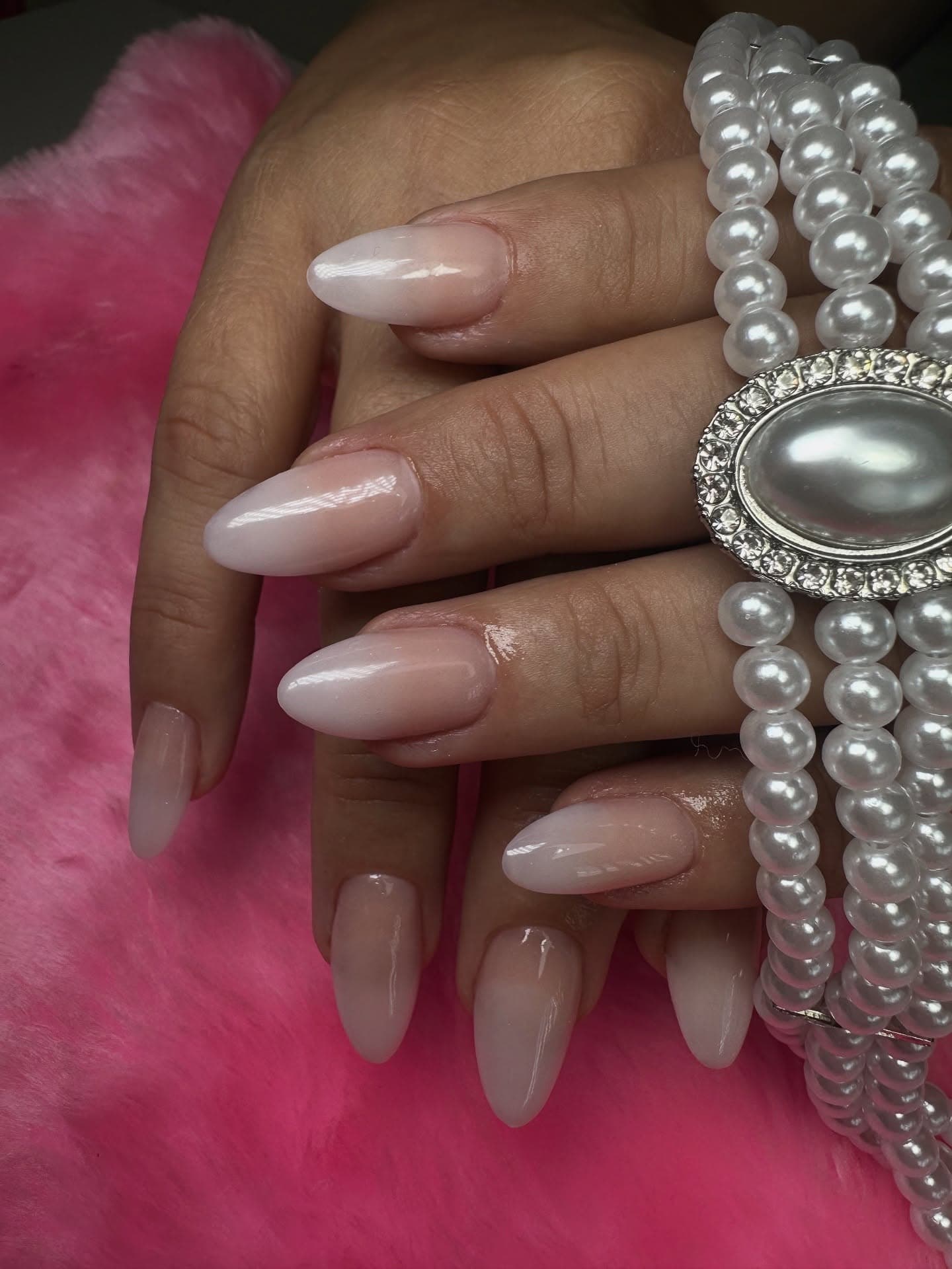 Uñas almendradas nude con perlas decorativas cosidas en cada dedo