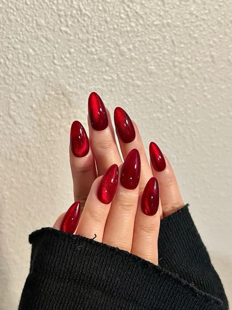 Dark red almond acrylic nails with chrome cat-eye shimmer effect