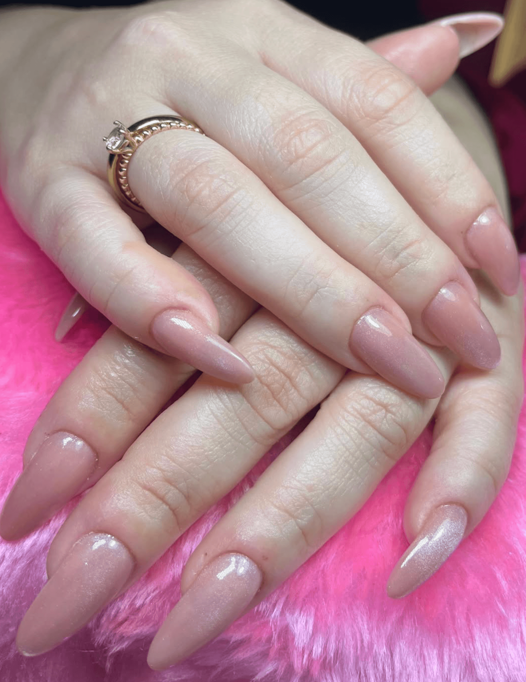 Nude blush almond acrylic nails with a gold ring detail