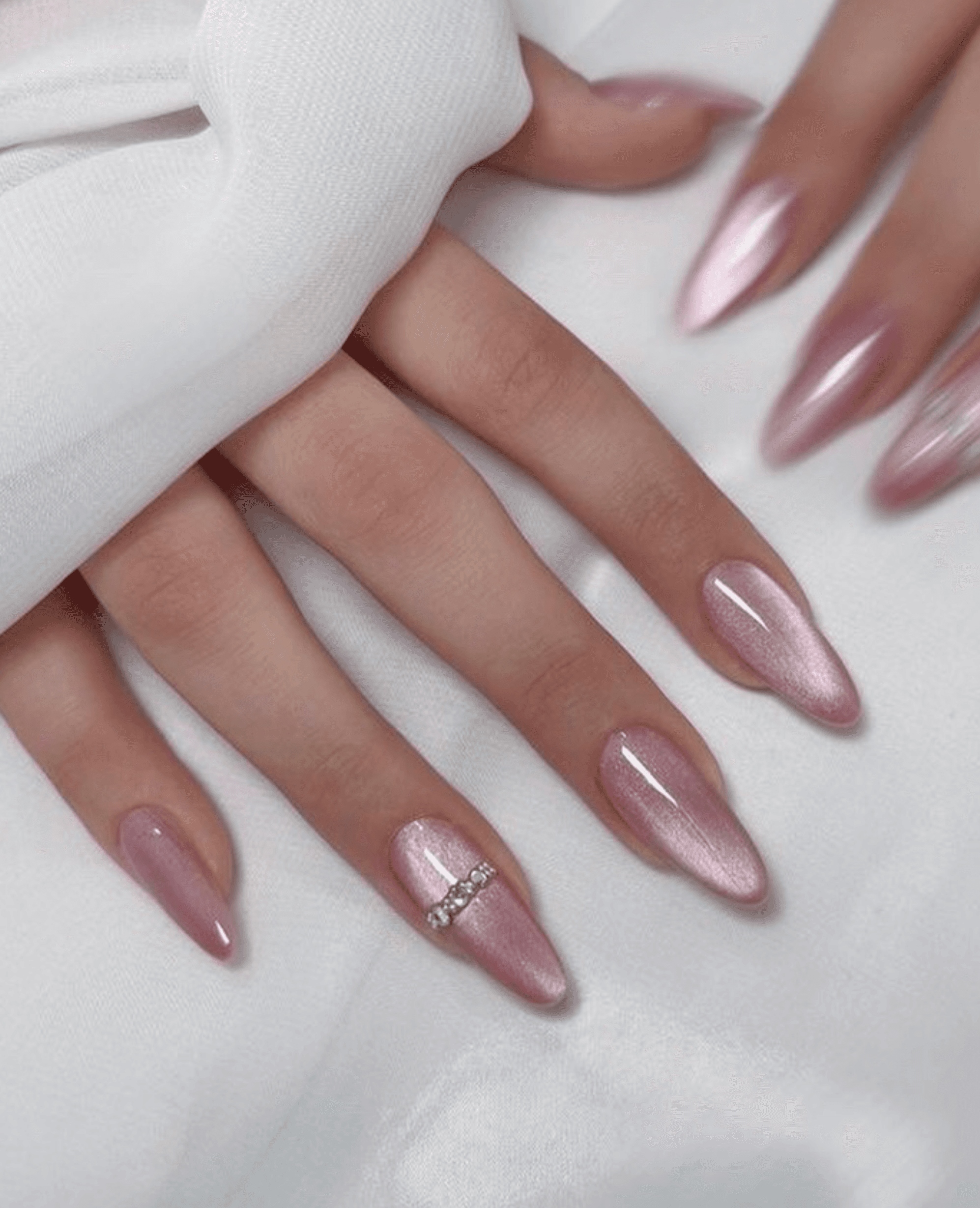 Pink chrome shimmer nails with holographic effect and crystal stones