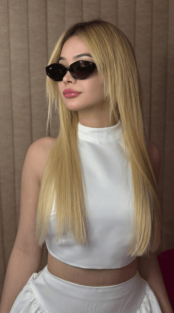 Dolls Coiffure stylist with long blonde hair, white top and sunglasses